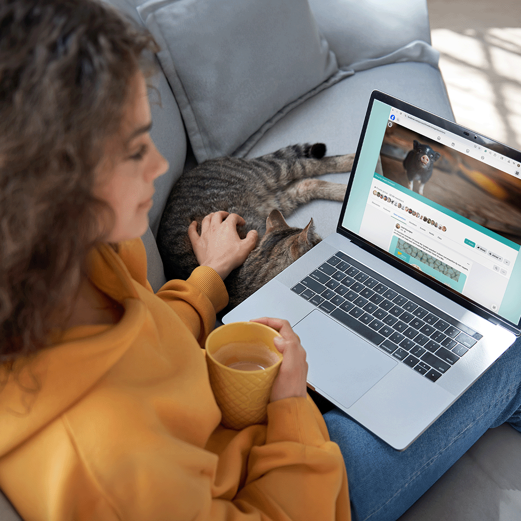 A woman with a laptop open to the 10 Weeks to Vegan Facebook community